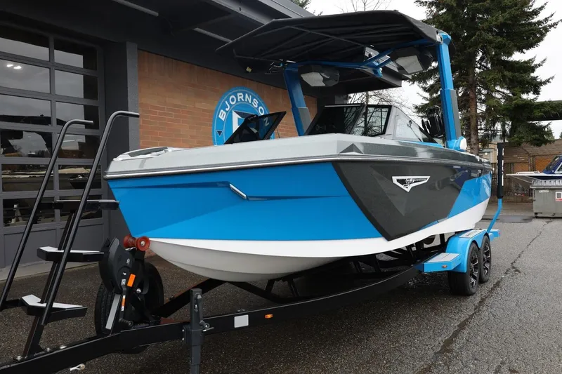 Slide: The Image of 2022 Nautique Super Air Nautique S23 boat in blue on trailer, parked outside. - 88