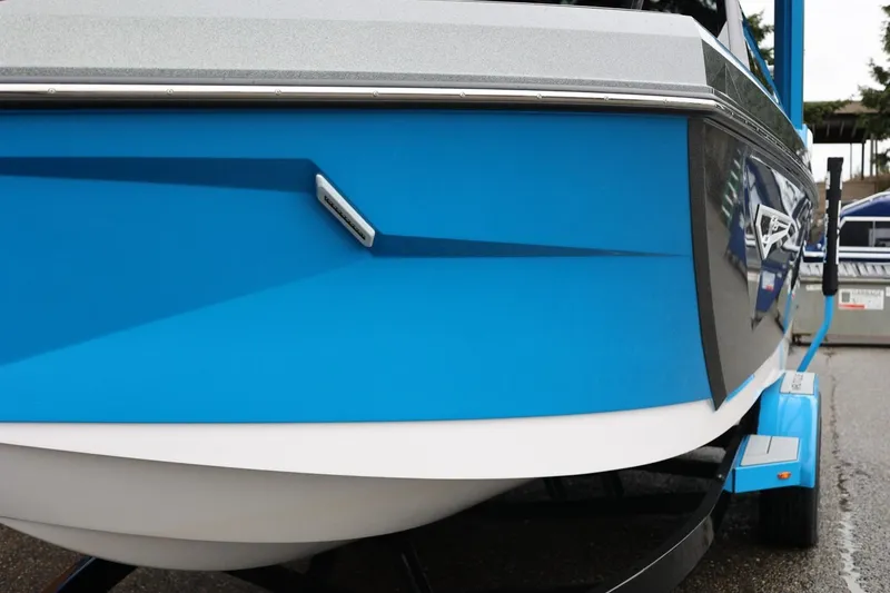 Slide: The Image of 2022 Nautique Super Air Nautique S23 boat, blue hull, on trailer. - 89