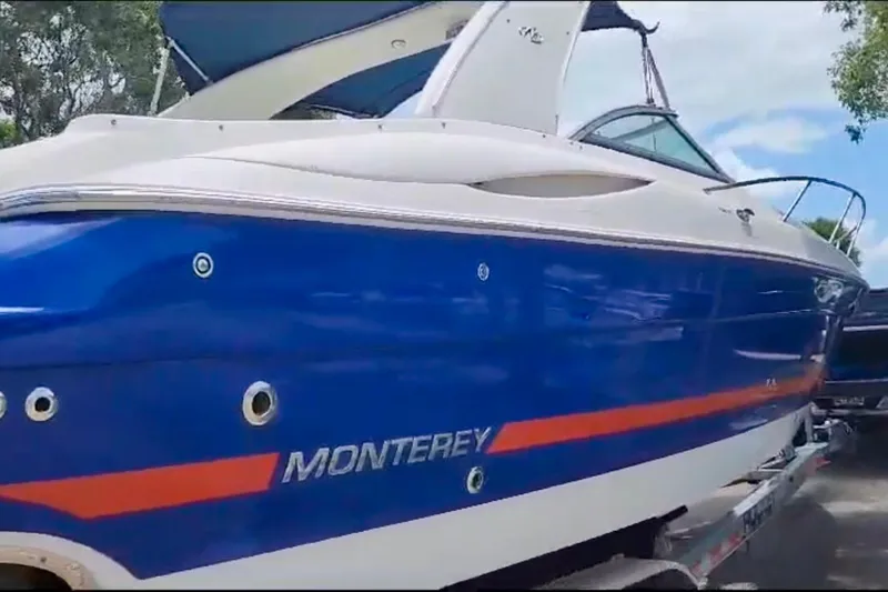 Slide: The Image of 2006 Monterey 298SC Super Sport boat on trailer, blue sky background, "Not This Trailer" text. - 2
