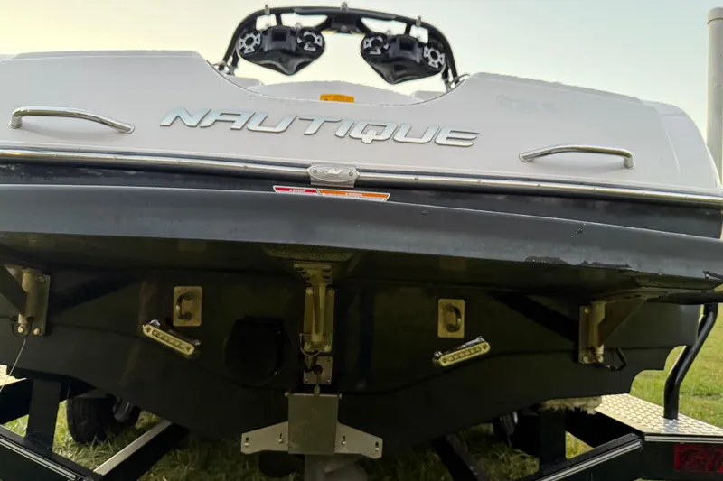 Slide: The Image of 2010 Nautique Super Air Nautique 230 boat rear view, showcasing brand logo and design. - 12