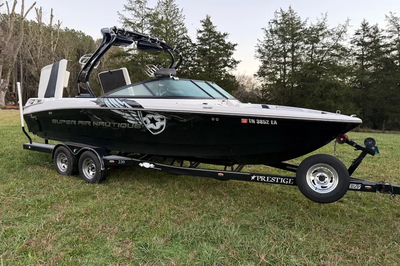 Slide: The Image of 2010 Nautique Super Air Nautique 230 boat on trailer in grassy area. - 5