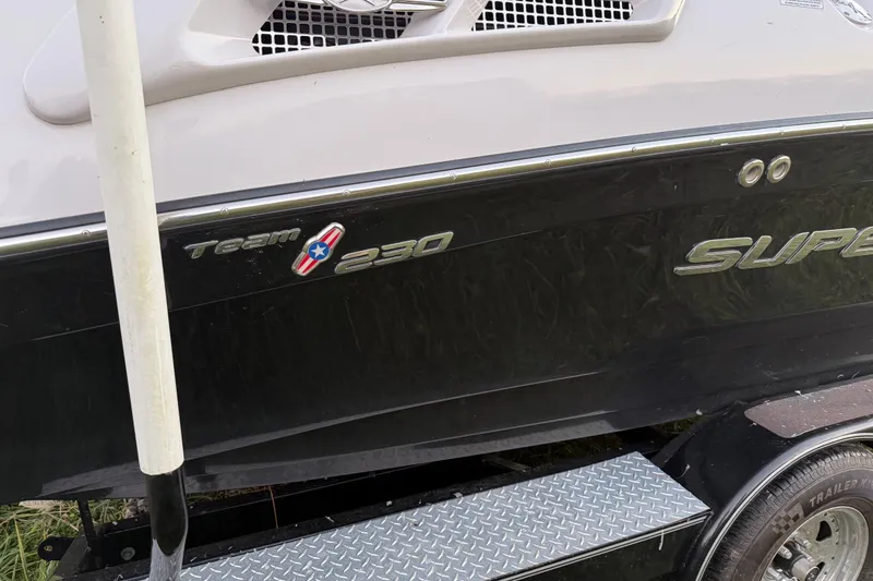 Slide: The Image of 2010 Nautique Super Air Nautique 230 boat side view with logo and trailer. - 6