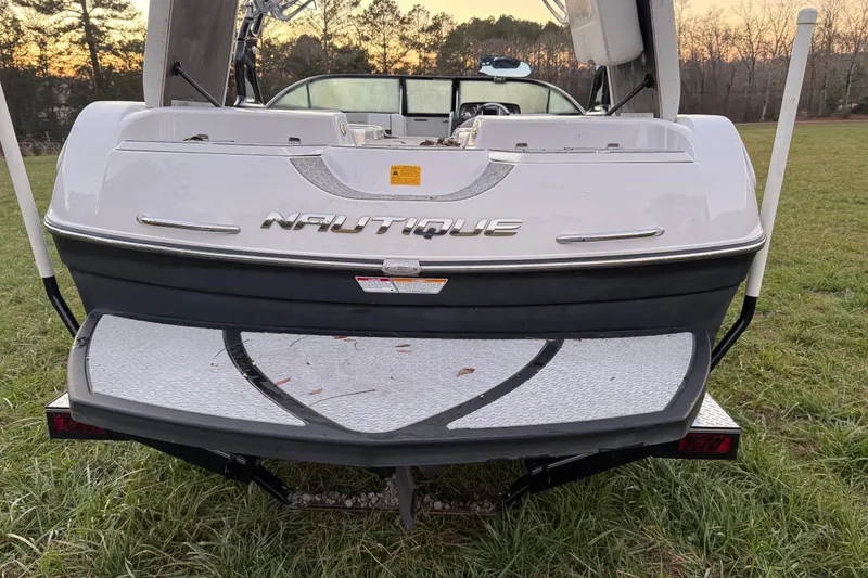 Slide: The Image of 2010 Nautique Super Air Nautique 230 boat rear view on grass. - 7