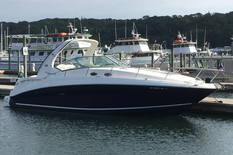 The Image of 2004 Sea Ray 320 Sundancer docked at a marina with other boats in the background. - 1
