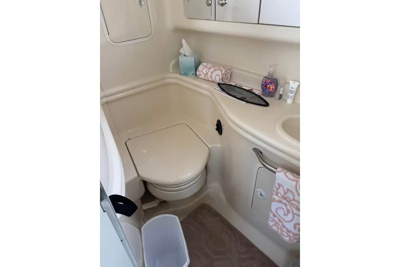Slide: The Image of 2004 Sea Ray 320 Sundancer bathroom with toilet, sink, and storage. - 15
