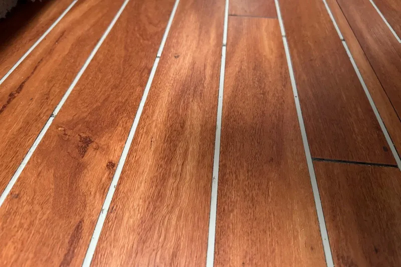 Slide: The Image of Teak flooring on 2004 Sea Ray 320 Sundancer boat, showcasing rich wood grain. - 16