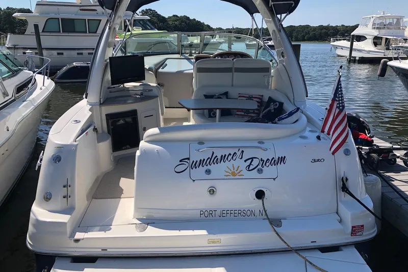 Slide: The Image of 2004 Sea Ray 320 Sundancer docked, featuring "Sundance's Dream" name and American flag. - 4
