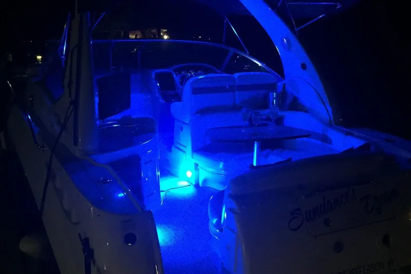 Slide: The Image of 2004 Sea Ray 320 Sundancer boat interior illuminated with blue LED lights at night. - 5