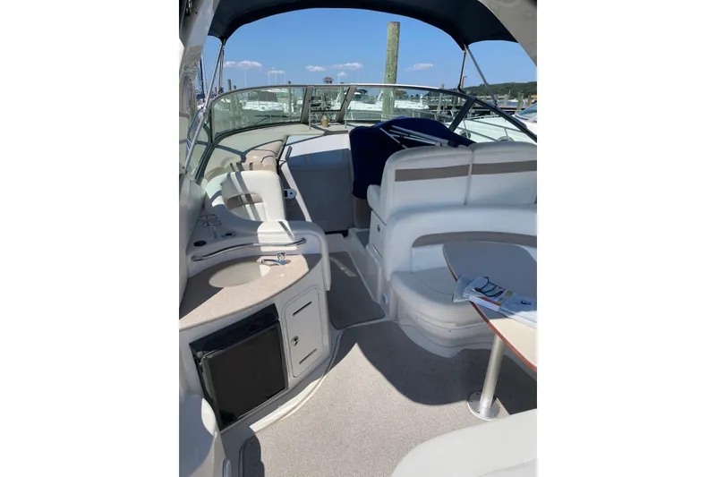 Slide: The Image of 2004 Sea Ray 320 Sundancer boat interior with seating and helm, docked at marina. - 8