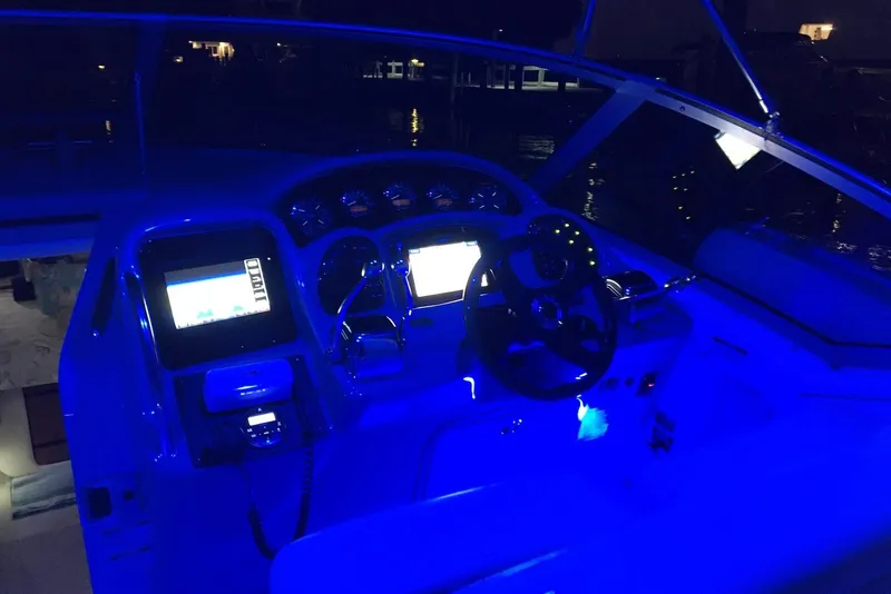 Slide: The Image of Cockpit of 2004 Sea Ray 320 Sundancer illuminated with blue lights at night. - 9
