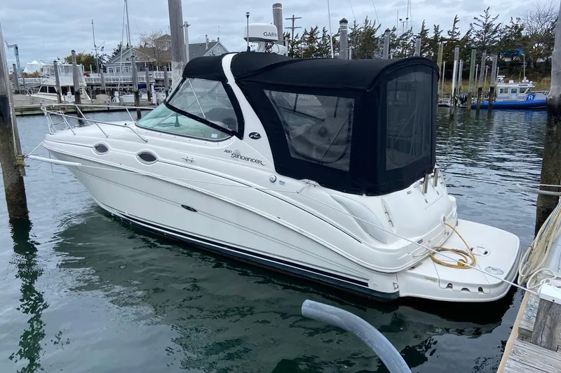 The Image of 2004 Sea Ray 280 Sundancer boat docked in a marina, featuring a sleek white design. - 1