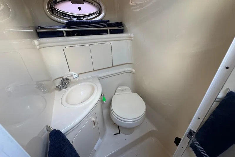 Slide: The Image of 2004 Sea Ray 280 Sundancer bathroom with sink, toilet, and porthole window. - 14