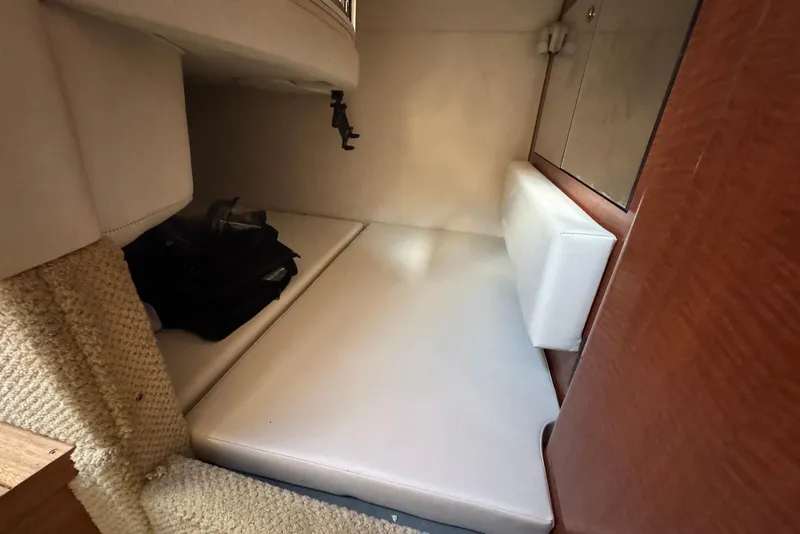 Slide: The Image of 2004 Sea Ray 280 Sundancer cabin interior with cushioned seating and storage. - 16