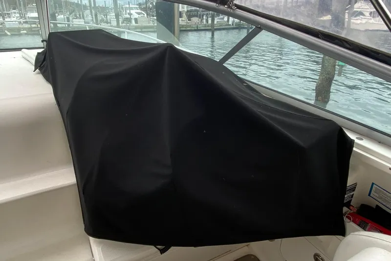 Slide: The Image of Covered dashboard on a 2004 Sea Ray 280 Sundancer boat, docked at a marina. - 18