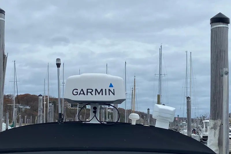 Slide: The Image of 2004 Sea Ray 280 Sundancer with Garmin radar, docked in a marina under cloudy skies. - 19