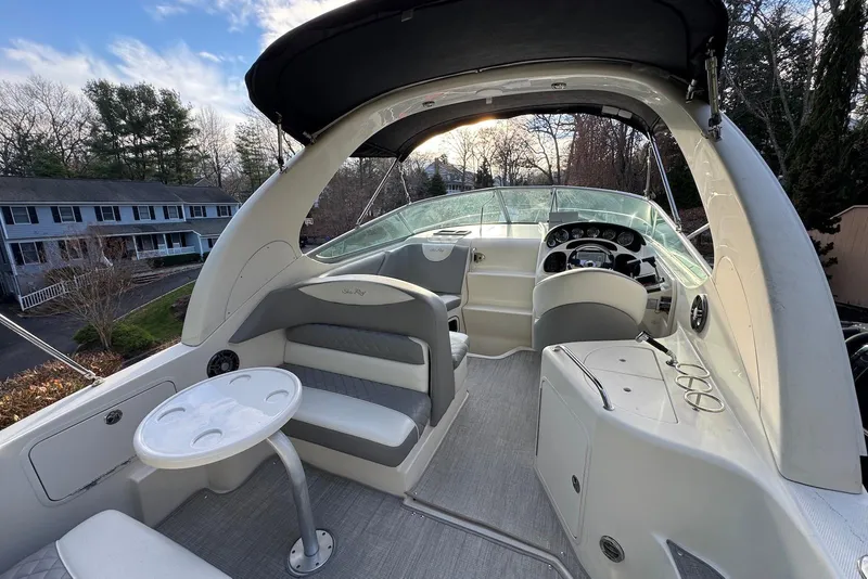 Slide: The Image of 2004 Sea Ray 280 Sundancer boat interior with seating, table, and helm under canopy. - 3