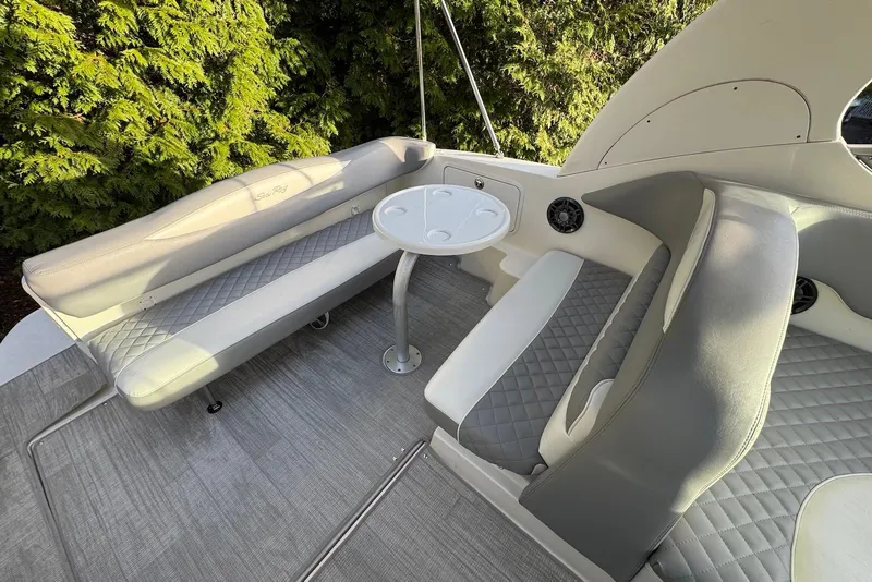 Slide: The Image of 2004 Sea Ray 280 Sundancer boat interior with cushioned seating and round table. - 4