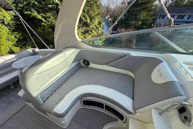 Slide: The Image of 2004 Sea Ray 280 Sundancer boat interior with cushioned seating and outdoor view. - 5