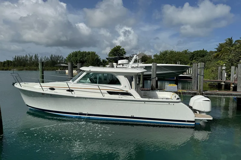 Slide: The Image of 2020 Back Cove 34O boat docked in a serene marina setting. - 10