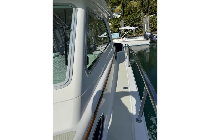 Slide: The Image of 2020 Back Cove 34O yacht side view with railing, docked near water. - 20