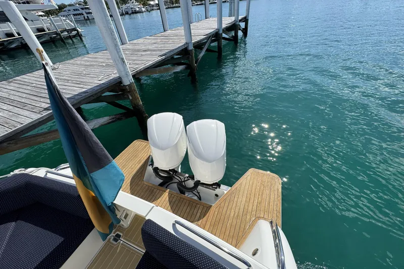 Slide: The Image of 2020 Back Cove 34O boat with dual engines docked by clear blue water. - 25