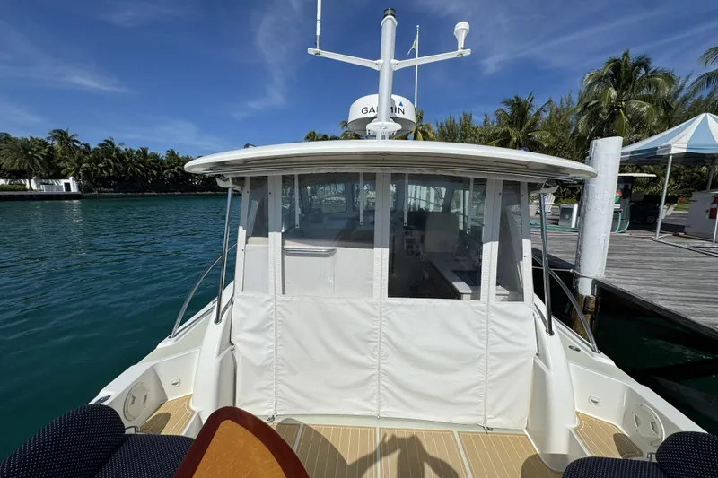 Slide: The Image of 2020 Back Cove 34O boat docked by tropical waterfront with clear skies. - 26