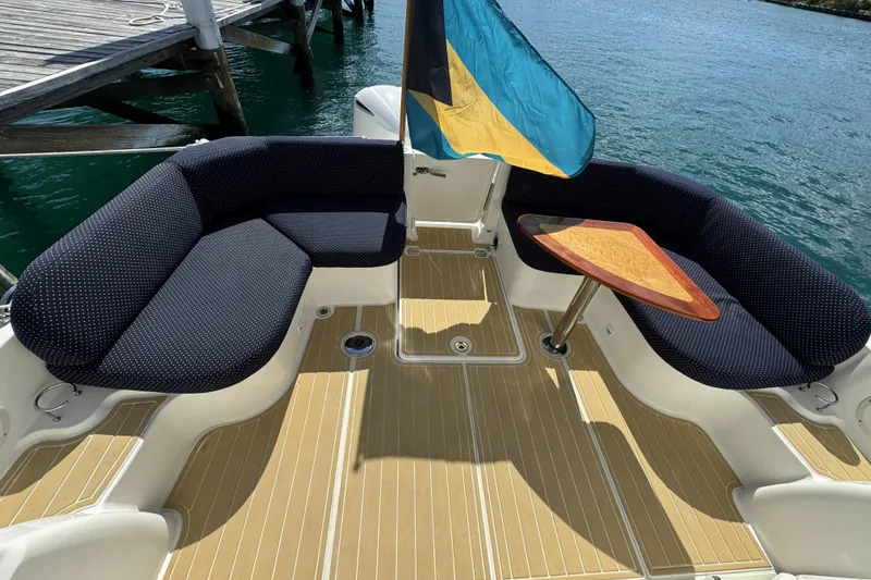 Slide: The Image of 2020 Back Cove 34O boat deck with seating and table, docked by the water. - 27
