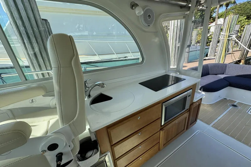 Slide: The Image of 2020 Back Cove 34O yacht interior with kitchenette, featuring stove, sink, and microwave. - 28