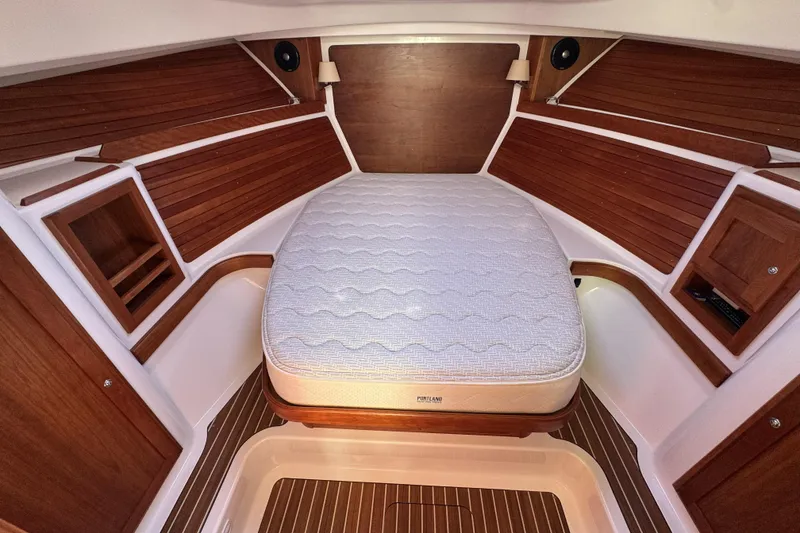 Slide: The Image of 2020 Back Cove 34O cabin interior with wooden paneling and a comfortable bed. - 4