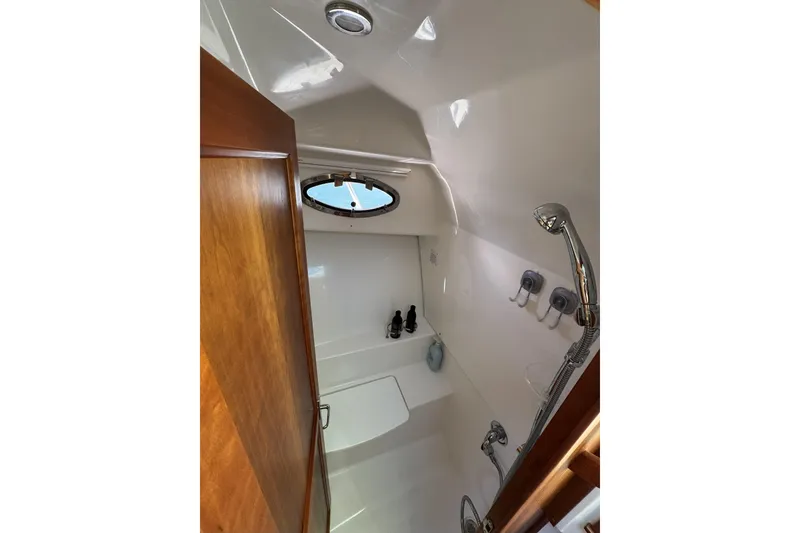 Slide: The Image of 2020 Back Cove 34O yacht bathroom with shower, wooden door, and porthole window. - 40