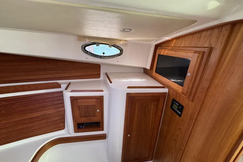 Slide: The Image of 2020 Back Cove 34O cabin interior with wood paneling and porthole window. - 42