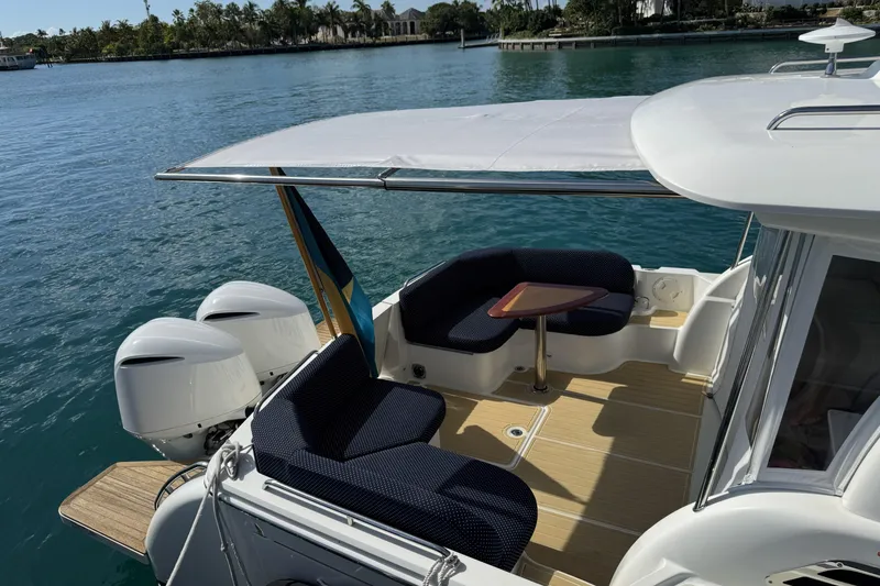 Slide: The Image of 2020 Back Cove 34O boat with seating area, canopy, and dual outboard engines on calm water. - 43