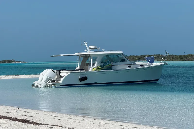 Slide: The Image of 2020 Back Cove 34O boat anchored on a sandy beach with turquoise water. - 45