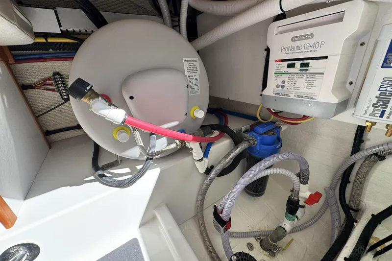 Slide: The Image of 2020 Back Cove 34O engine compartment with ProMariner ProNautic charger and plumbing system. - 48