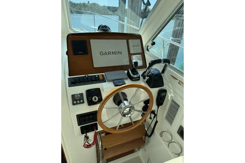Slide: The Image of 2020 Back Cove 34O helm with Garmin navigation, wooden steering wheel, and control panel. - 6