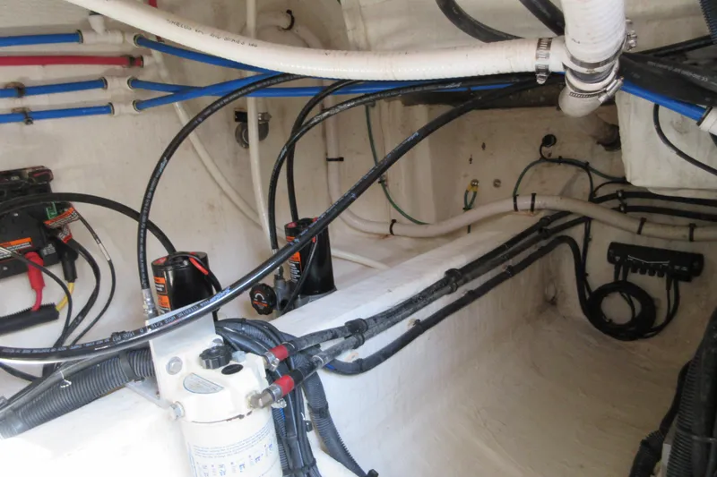 Slide: The Image of Engine compartment of a 2020 Back Cove 34O boat, showcasing wiring and plumbing. - 67