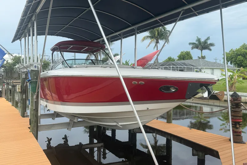 The Image of Red 2007 Cobalt 343 boat docked under a canopy, surrounded by tropical scenery. - 0