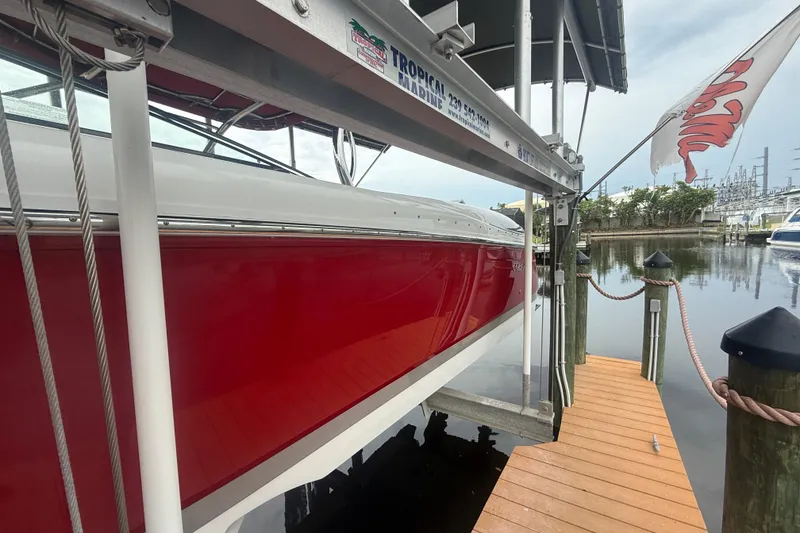 Slide: The Image of Red 2007 Cobalt 343 boat docked on a lift at a marina. - 2