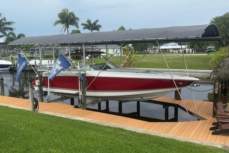 Slide: The Image of Red 2007 Cobalt 343 boat docked under canopy, surrounded by lush greenery and palm trees. - 3