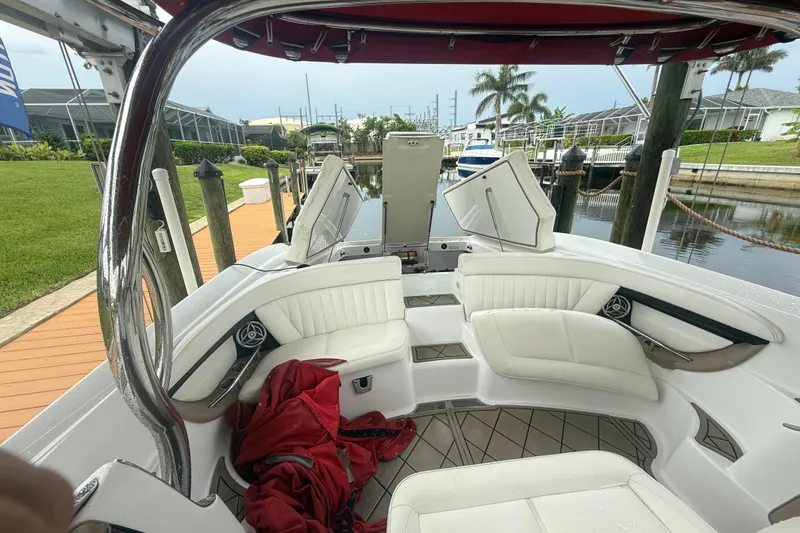 Slide: The Image of 2007 Cobalt 343 boat interior with white seating and red canopy, docked by a canal. - 8