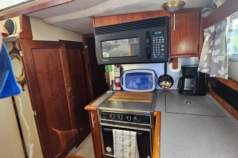Slide: The Image of 1991 Bayliner 3888 Motoryacht kitchen with microwave, stove, and coffee maker. - 19