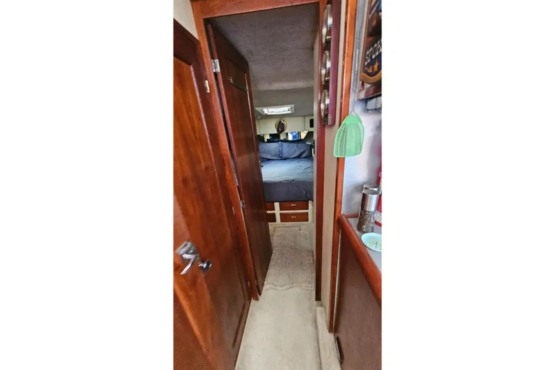 Slide: The Image of Interior hallway of 1991 Bayliner 3888 Motoryacht with wood paneling and cozy bedroom. - 23