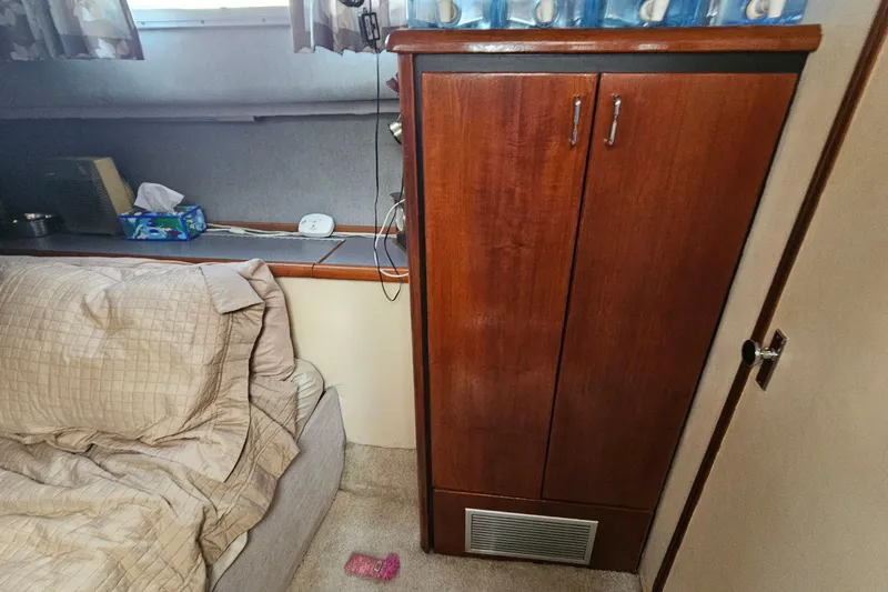 Slide: The Image of 1991 Bayliner 3888 Motoryacht interior with wooden cabinet and cozy bedding. - 24