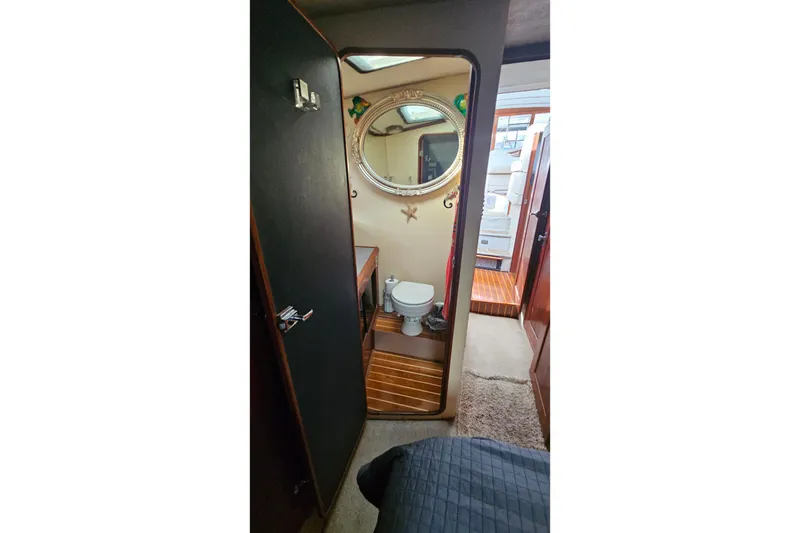 Slide: The Image of Interior of 1991 Bayliner 3888 Motoryacht showing bathroom with mirror and wooden flooring. - 27