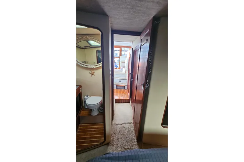 Slide: The Image of Interior of 1991 Bayliner 3888 Motoryacht, featuring a compact bathroom and hallway. - 28