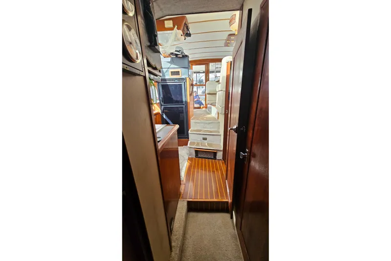 Slide: The Image of Interior view of 1991 Bayliner 3888 Motoryacht, showcasing wood finishes and cozy cabin layout. - 29