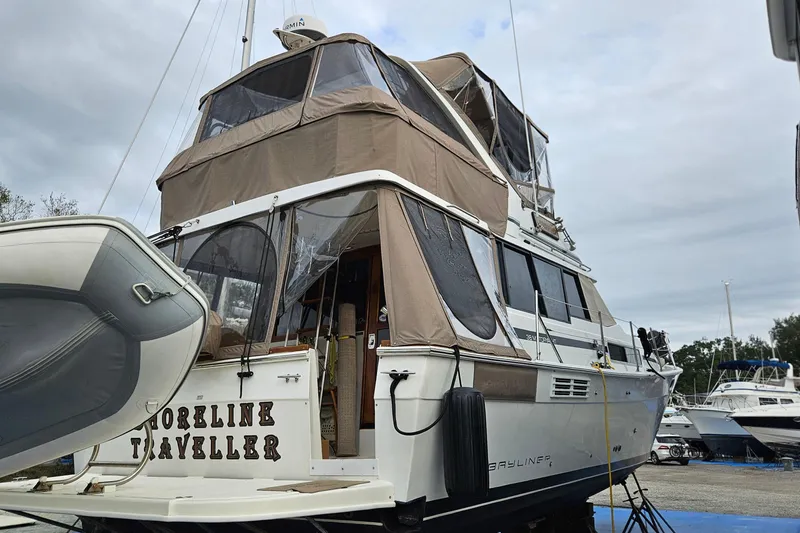 Slide: The Image of 1991 Bayliner 3888 Motoryacht on stands, featuring enclosed upper deck and sleek design. - 3