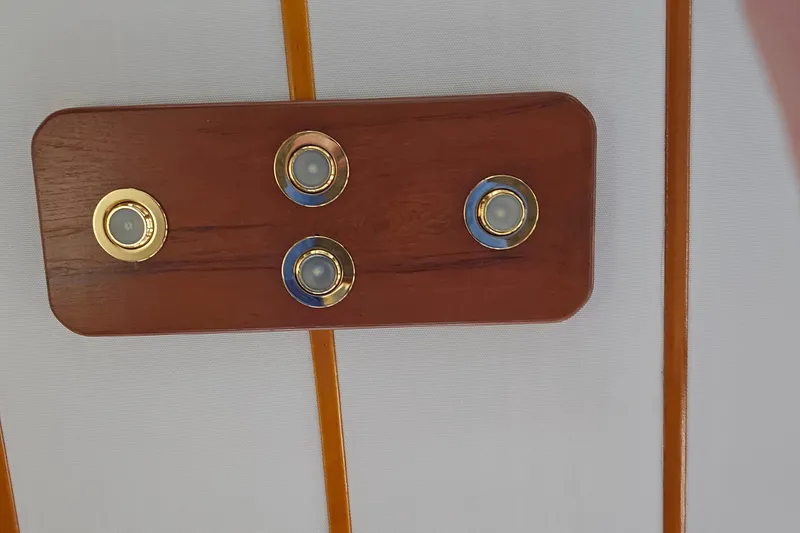 Slide: The Image of Wooden panel with four brass-accented lights on a 1991 Bayliner 3888 Motoryacht. - 31