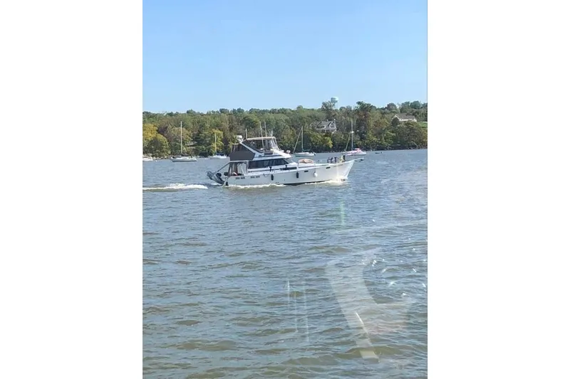 Slide: The Image of 1991 Bayliner 3888 Motoryacht docked, featuring spacious deck and covered cockpit. - 7