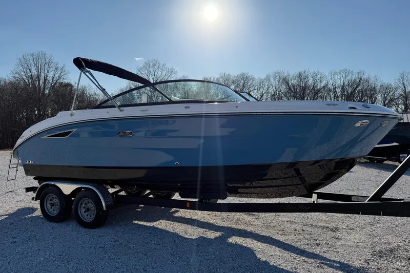 Slide: The Image of 2026 Sea Ray SDX 230 boat on trailer under bright sun, parked on gravel. - 4